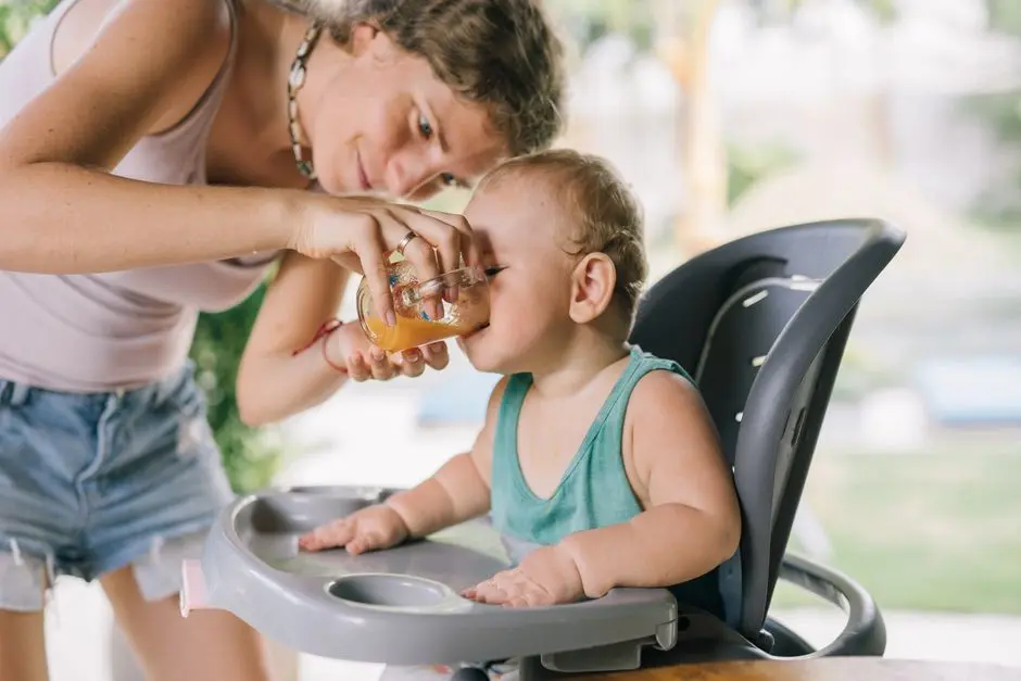 Anak balita makan MPASI di kursi makan dengan ibu di samping